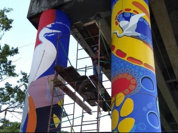 Acayuqueño pinta murales en columnas de puente en Coatzacoalcos