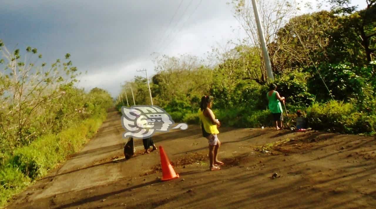 Tapando baches de la carretera, familias serranas buscan el sustento