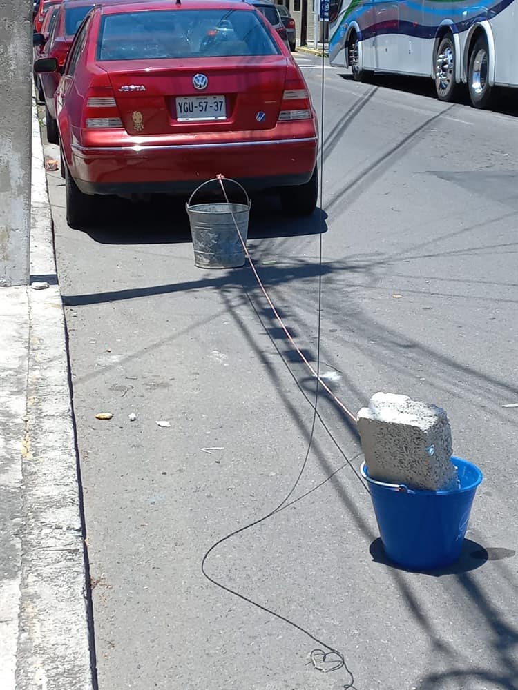 Vecinos protegen sus cocheras con cubetas para evitar daños por Carnaval de Veracruz