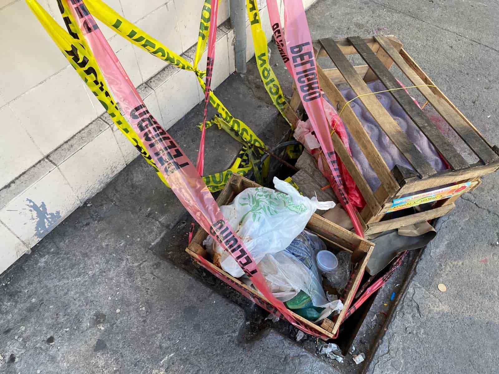 Comerciantes tapan de forma casera registros de luz sin tapa en el mercado Hidalgo