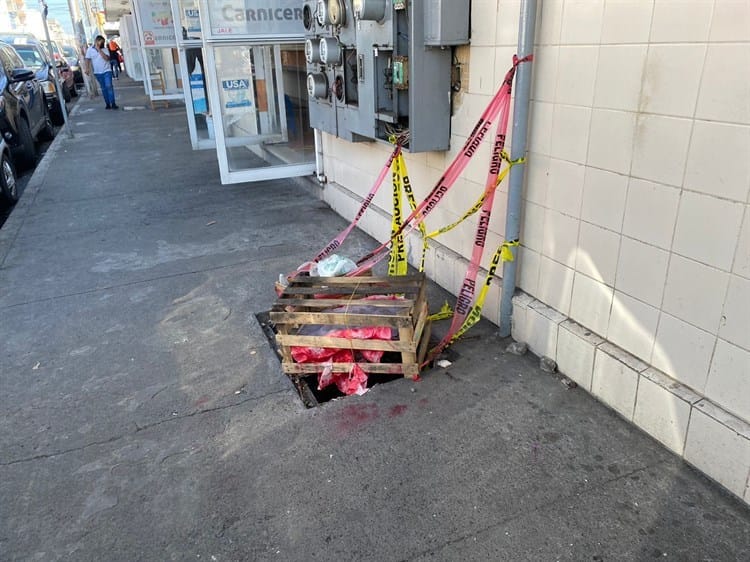 Comerciantes tapan de forma casera registros de luz sin tapa en el mercado Hidalgo