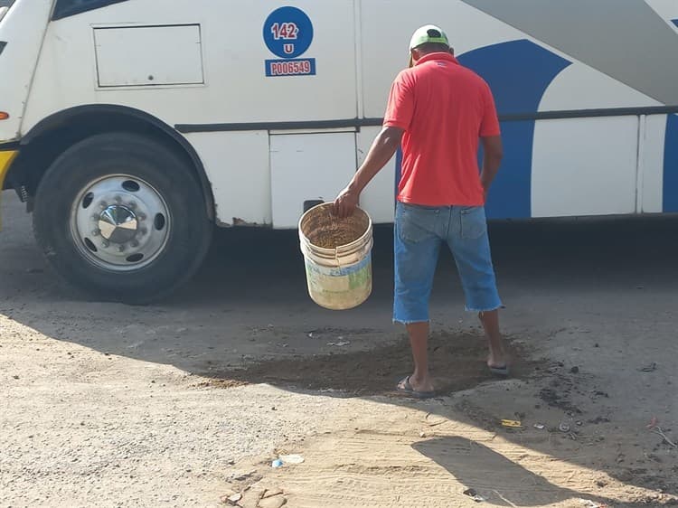 Cristóbal y Lucho rellenan con escombro enormes baches que se formaron en Lomas 4