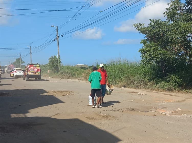 Cristóbal y Lucho rellenan con escombro enormes baches que se formaron en Lomas 4