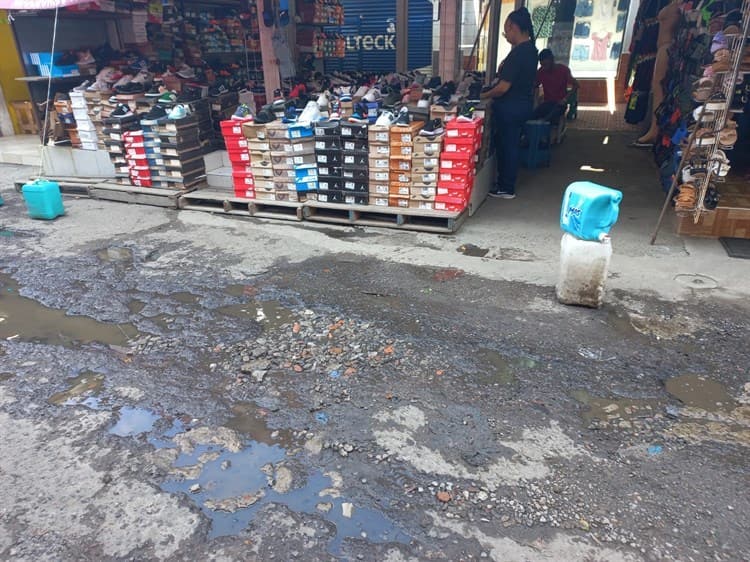 Con escombros y adoquines ciudadanos rellenan baches en el centro de Veracruz