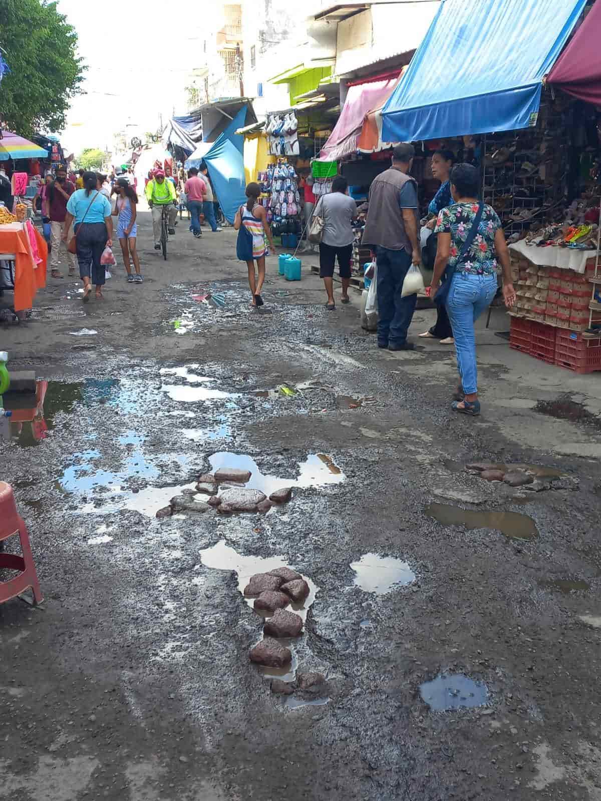 Con escombros y adoquines ciudadanos rellenan baches en el centro de Veracruz