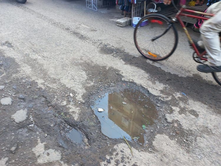 Con escombros y adoquines ciudadanos rellenan baches en el centro de Veracruz