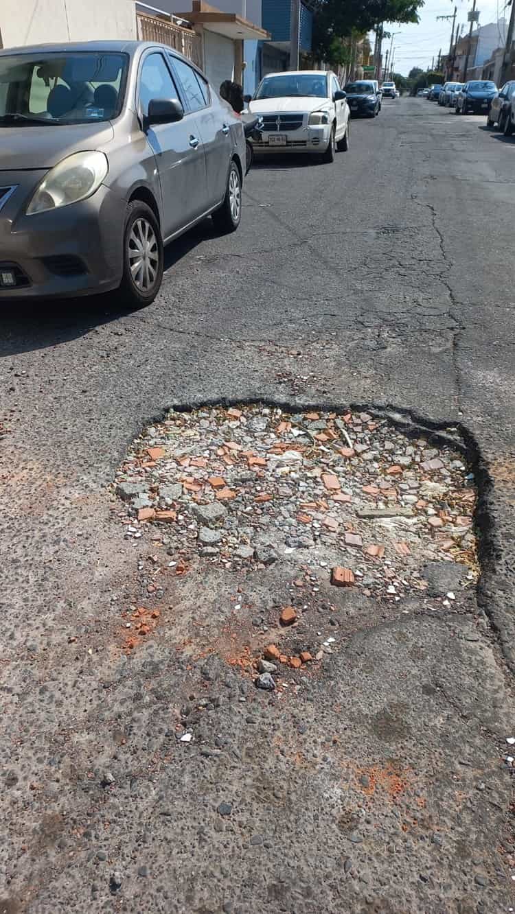 Crece bache en el Virginia, llaman a taparlo para evitar accidente