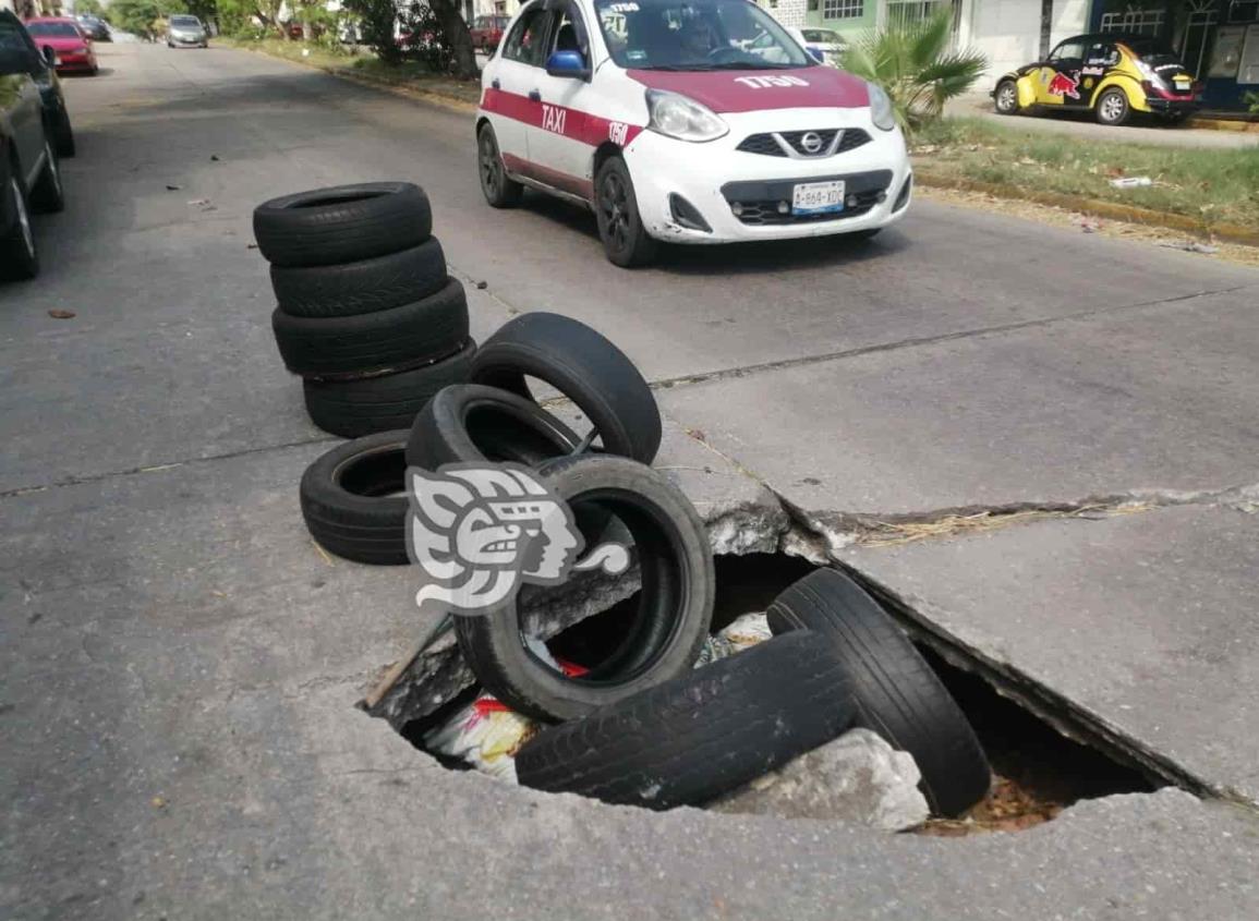 ¡Hasta con cubetas!; Alertan por calles en mal estado