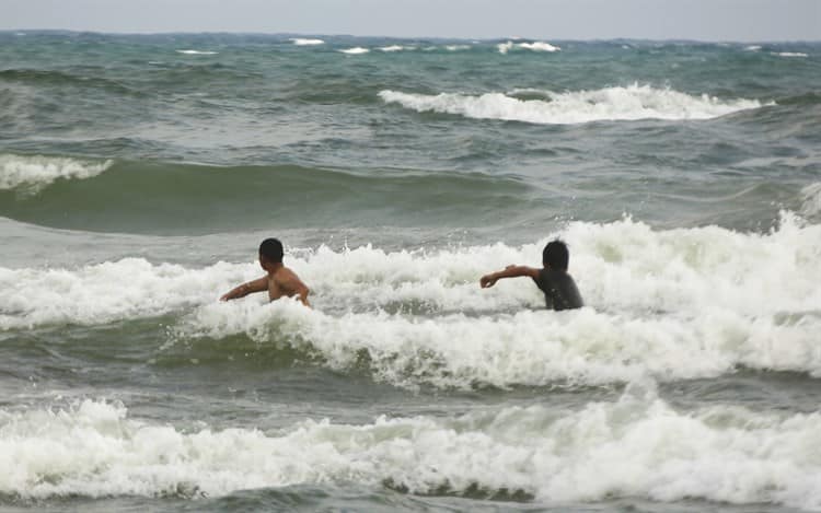 ¡Nada los detiene!, ingresan a la playa a pesar de fuerte oleaje en Coatzacoalcos