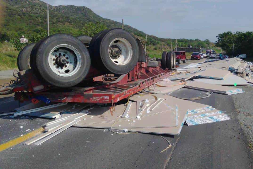 Vuelca plana de tráiler y arrasa con 2 autos en Alto Lucero