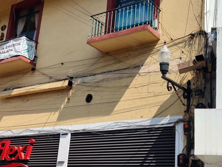 Estructura metálica cae sobre taxi en Xalapa