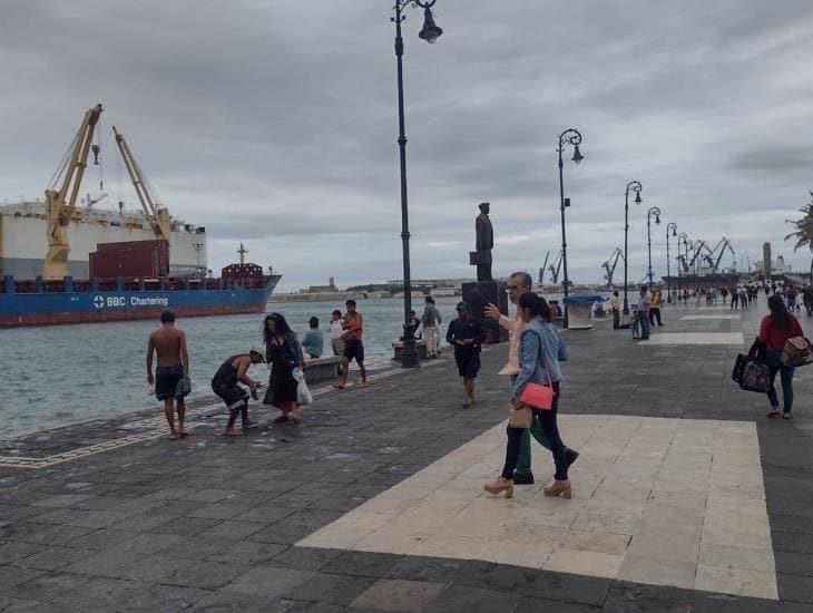 Frente frío 9 no espanta a turistas en malecón de Veracruz