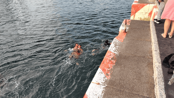 Sacamonedas ebrio cae al mar en malecón de Veracruz y es rescatado por compañeros | VIDEO