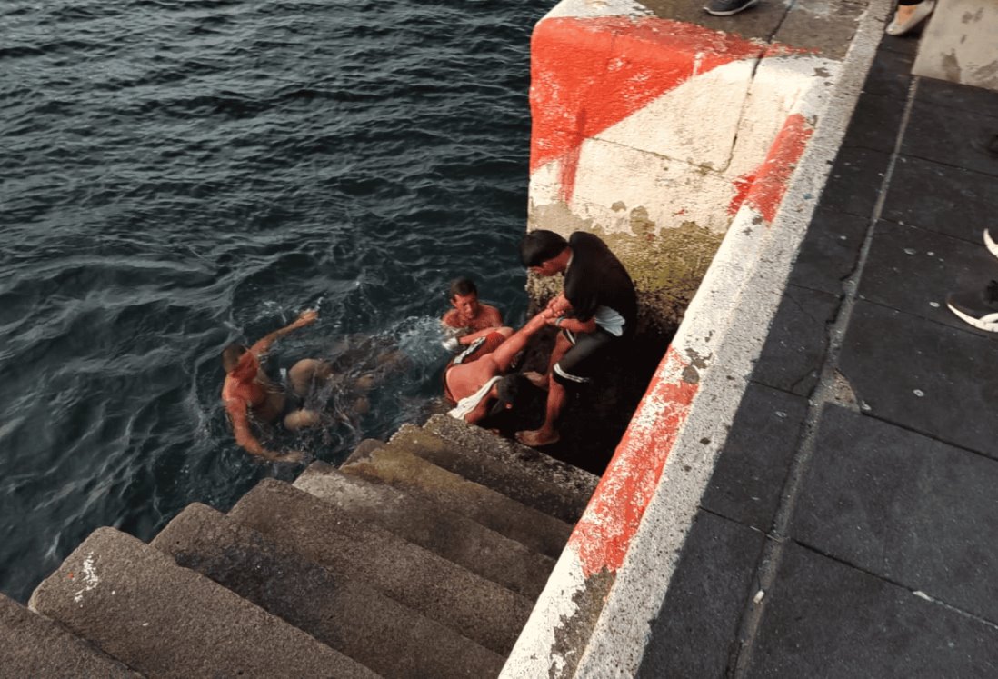 Sacamonedas ebrio cae al mar en malecón de Veracruz y es rescatado por compañeros | VIDEO