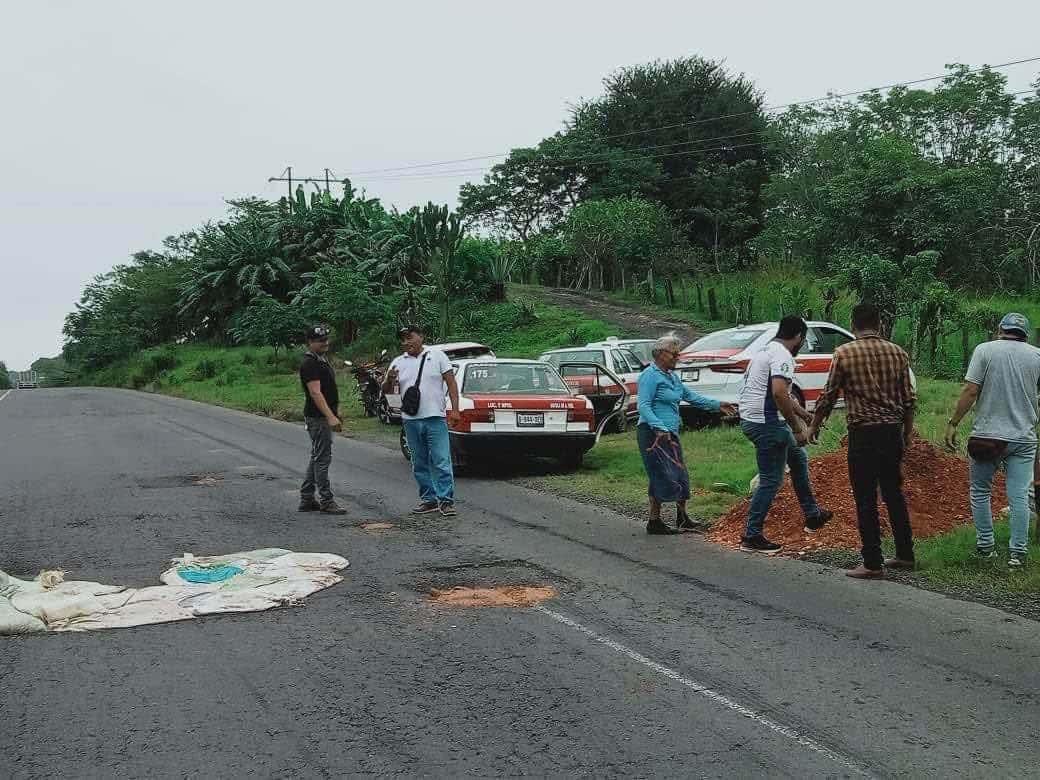 Taxistas de Sayula de Alemán bachean carretera Transístmica para reducir accidentes