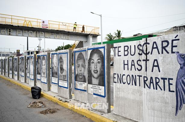 Colectivos dan mantenimiento a fotografías  en muro de desaparecidos en Veracruz