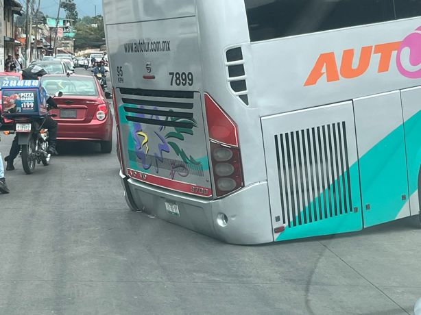 Desnivel traicionero: autobús se atora en plena vía pública, en Xalapa