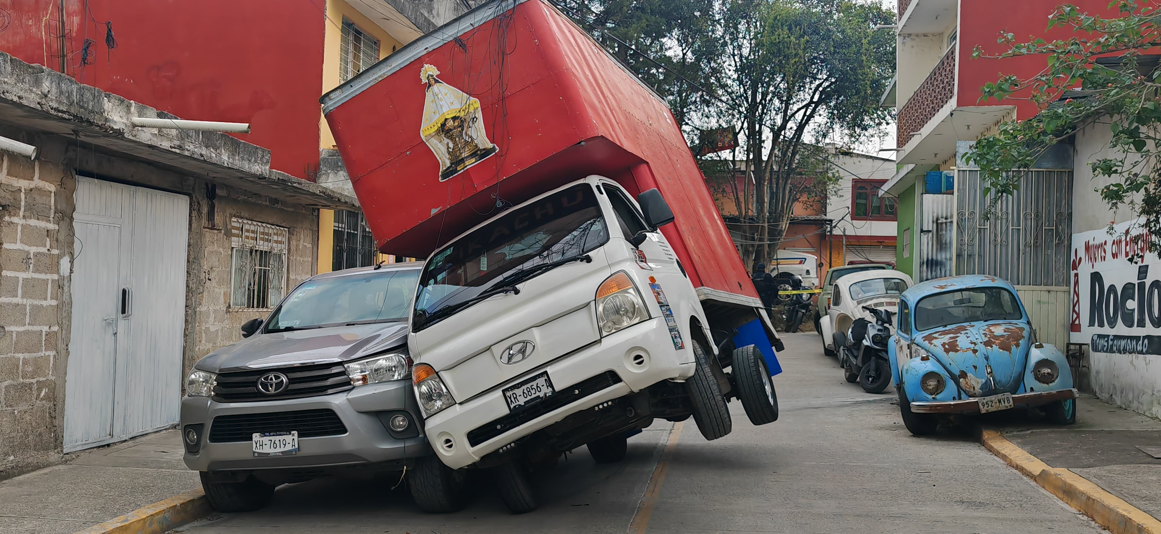 Camioneta queda recargada sobre otra tras jalar cables eléctricos en Xalapa